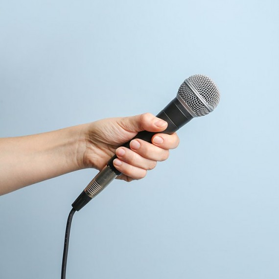 Interviewpartner aus der Pflege gesucht? eine Hand hält ein Mikrophon